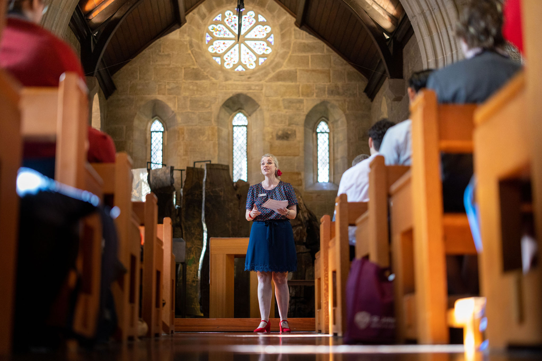 Speaker standing at the front of a church addressing seated students.