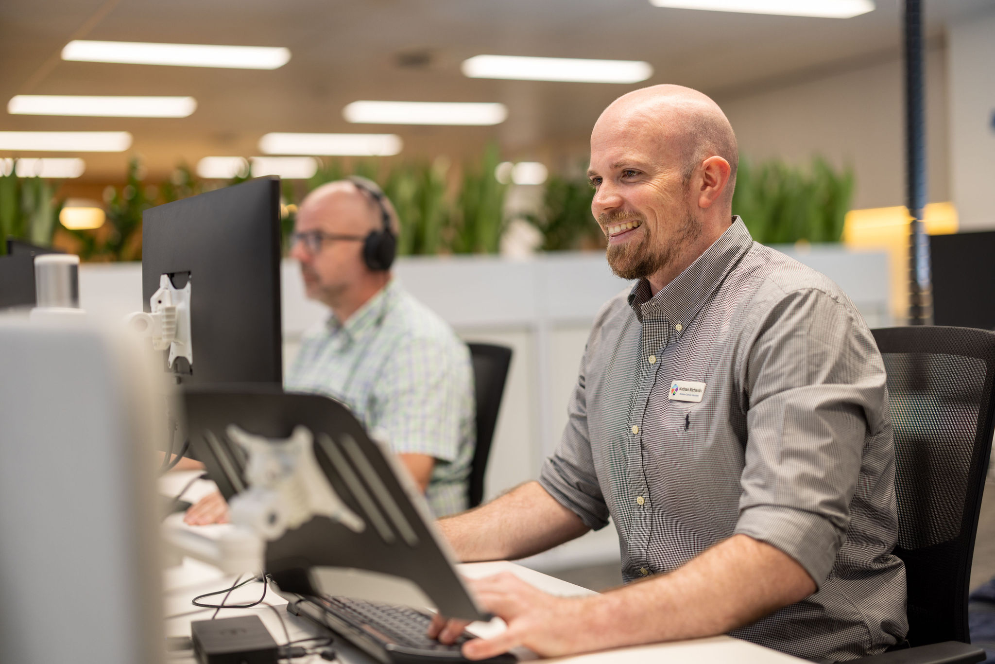 Staff members working at computers in an office workspace.