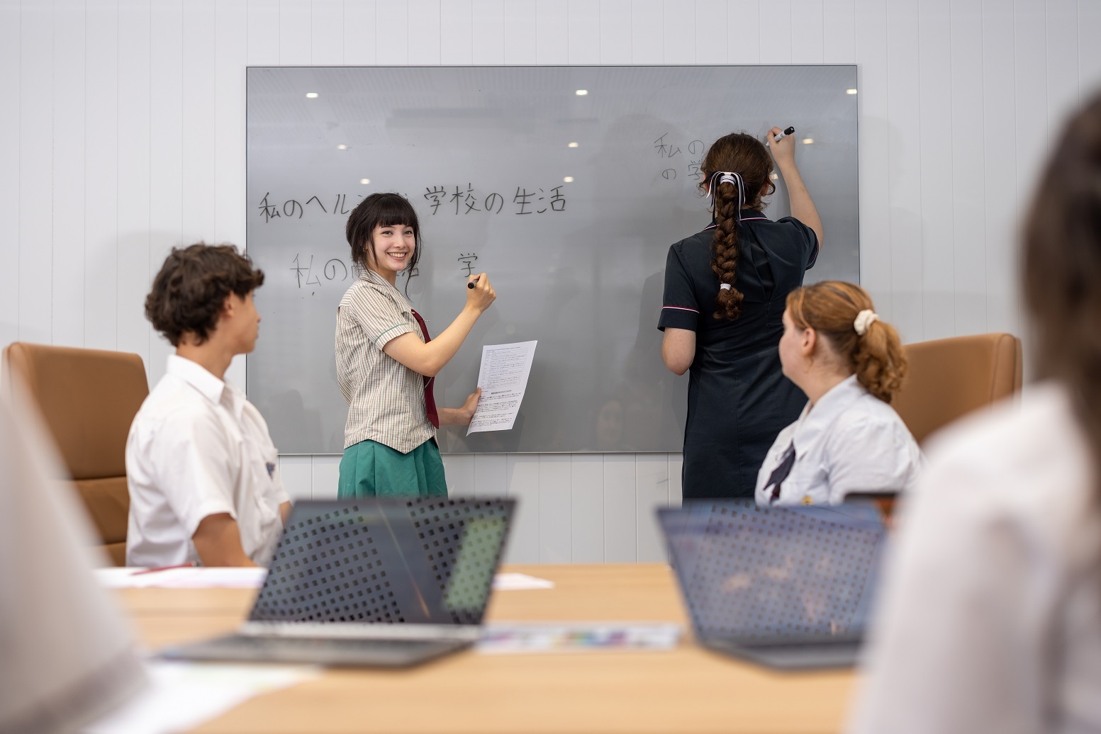 Students working together during a language lesson at a whiteboard.