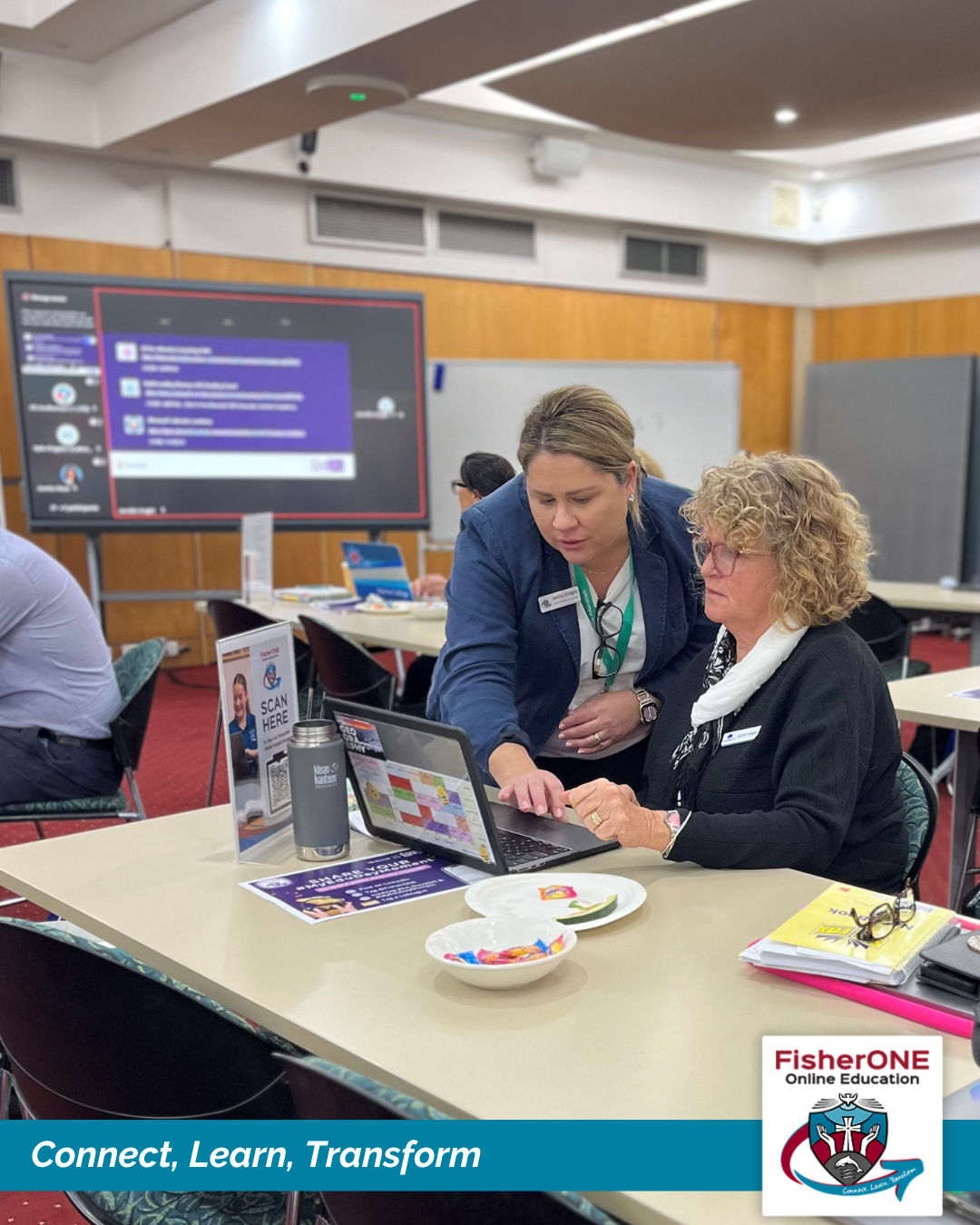 Staff members working together at a laptop during a professional learning session.