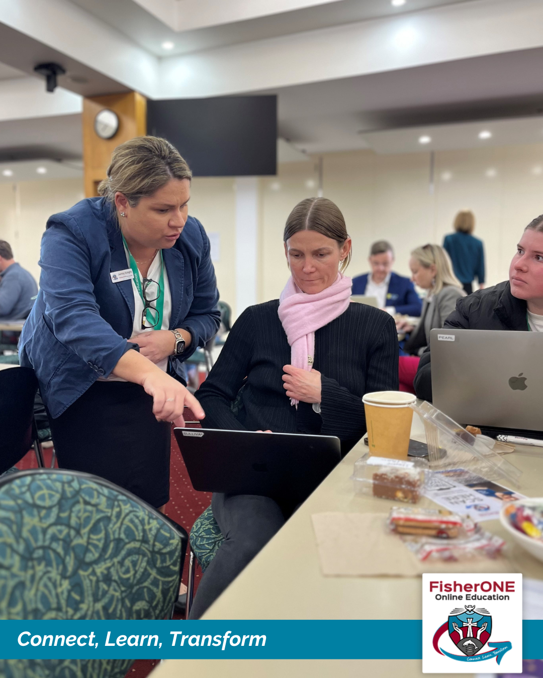 Staff members working together at a laptop during a professional learning session.